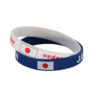 Detail of blue and white Japan silicone sports bracelets with flag and logo print
