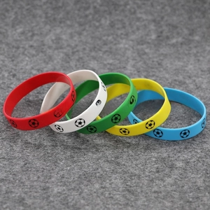 Détail de cinq bracelets en silicone colorés avec motifs de football classiques