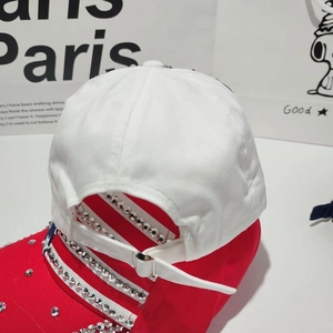 Close-up of baseball cap featuring red rhinestone brim and adjustable silver buckle