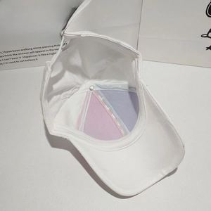 Detail of adjustable metal buckle and pink-purple patchwork lining inside the baseball cap