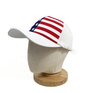 White baseball cap with American flag patch and curved brim on a display mannequin