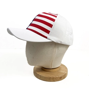 Detail of white cotton baseball cap featuring red and white striped panels with premium stitching