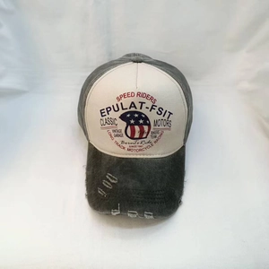 Macro shot of distressed washed gray canvas and vintage motor racing embroidery on baseball cap