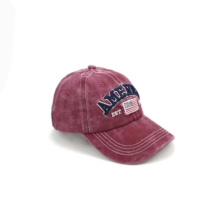 Detailed view of American flag embroidery on a vintage washed burgundy baseball cap