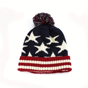 Winter knitted beanie with US flag stars and stripes pattern and colorful pompom