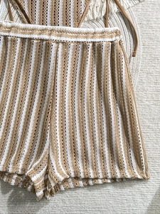 Detailed macro view of brown and white striped crochet knit shorts with elastic waist