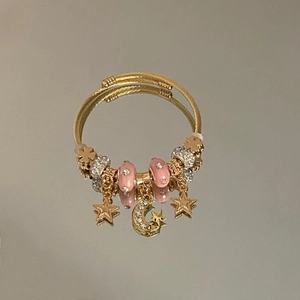 Elegant gold celestial spiral bangle with sparkling star and moon zircon charms