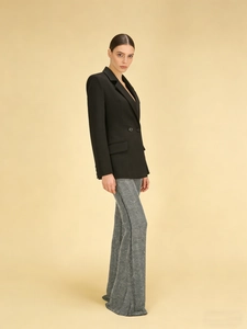 Tailleur chic avec blazer noir à col en V et pantalon gris à jambes larges en studio