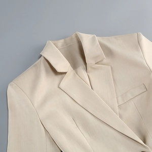 Détail du tissu de blazer beige clair avec revers cranté et poche sur la poitrine