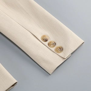 Gros plan détaillé de la manche du blazer beige avec sergé et trois boutons ambre