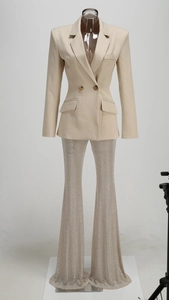 Détail d'un blazer croisé beige et d'un pantalon évasé argenté scintillant à paillettes