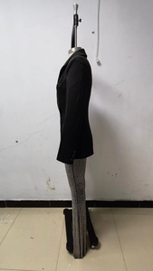 Détail d'un blazer noir cintré associé à un pantalon gris argenté à motifs texturés