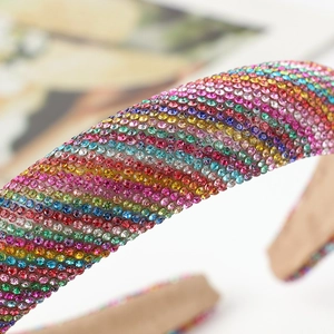Padded headband featuring shimmering multi-color rhinestones in a rainbow stripe pattern