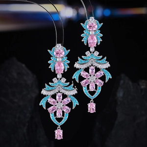 Detailed close-up of handmade baroque earrings with pink stones and blue accents