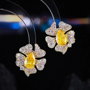 Macro view of floral earrings with yellow pear-cut stones and crystal pavé details