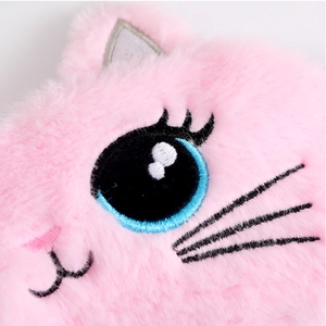 Close-up of pink plush cat eye mask with blue embroidered eye and soft faux fur texture