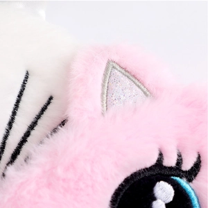Detailed close-up of pink plush cat sleep mask with glitter ears and blue eye embroidery
