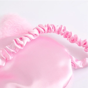 Detail of pink satin cat sleep mask with plush ears and elastic headband