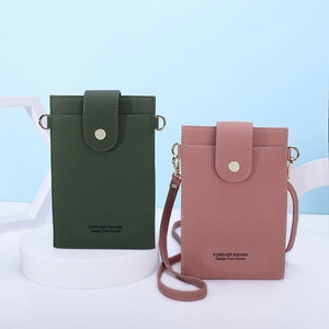 Close-up of lychee grain leather crossbody phone bags in dark green and dusty pink