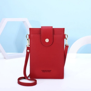 Detailed macro view of red lychee grain leather phone bag with gold metal ring and flap