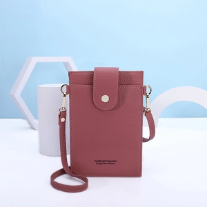 Detailed view of dusty pink crossbody phone bag with lychee texture and snap button closure