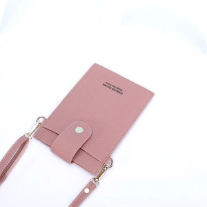 Detailed macro of pink pebbled leather mini crossbody bag with gold-tone hardware