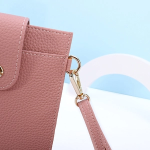 Detail of pink lychee leather phone bag with gold hardware and fine white stitching