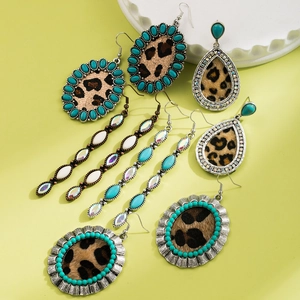 Dettagli di orecchini boho con stampa leopardata, perle turchesi e finiture dorate
