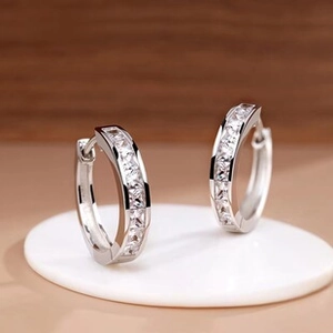 Macro detail of S925 sterling silver hoop earrings with channel-set white zircon stones