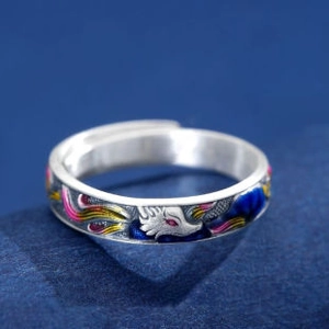 Macro shot of silver fox ring with colorful enamel clouds and red eye detail