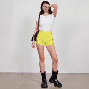 Women's trendy high waist yellow denim shorts with side lace-up cutout detail and white T-shirt
