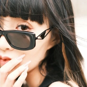 Chic black small frame sunglasses with hollow triangle temple design on Asian model