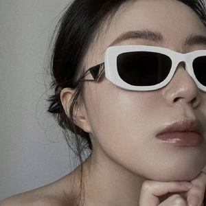 White wide-frame sunglasses with tinted lenses and signature metal triangle temple detail