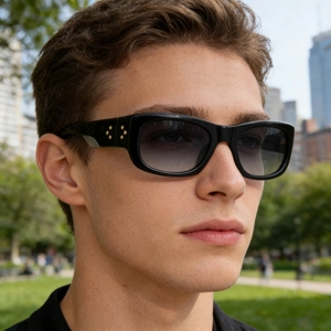 Detail of black sports sunglasses with gradient blue lenses and golden star studs on temple