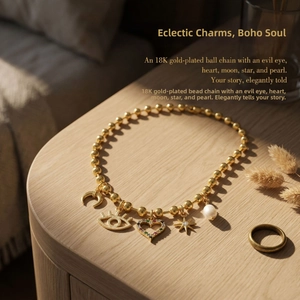 Detailed view of 18K gold-plated ball chain with moon, evil eye, star and pearl charms