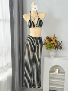 Détail du haut de bikini au crochet avec breloque coquillage doré et motif à rayures