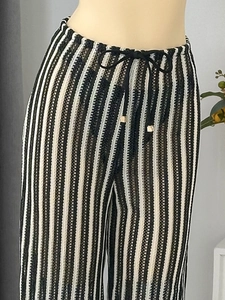 Détail d'un pantalon en maille crochet à rayures noires et blanches avec cordon de serrage