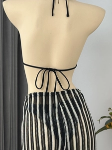 Vue arrière du haut licou noir noué et de la jupe en tricot transparent à rayures noir et blanc