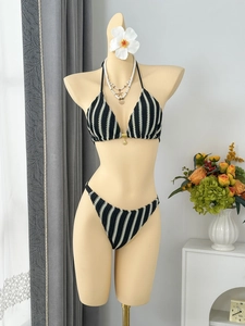 Détail du bikini en crochet à rayures noires et blanches avec breloque dorée sur mannequin