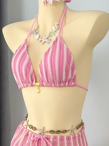 Détail du bikini en crochet à rayures roses et blanches avec bijoux coquillages et étoiles