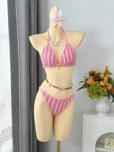 Gros plan sur le maillot de bain crochet rayé rose avec pendentif coquillage et maille