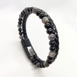 Macro detail of men's leather braided bracelet with tiger eye beads and magnetic clasp