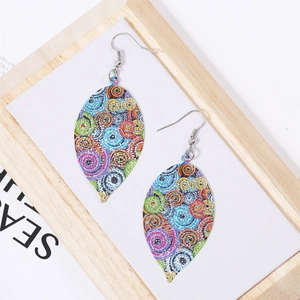 Detailed macro view of bohemian leaf-shaped earrings with colorful spiral patterns