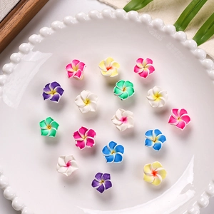 Close-up of 16mm multi-colored polymer clay frangipani charms in a ceramic dish