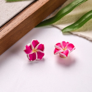 Detail of 16mm pink clay Plumeria flower earrings with realistic petal texture