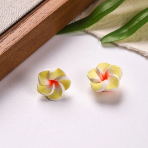 Macro view of 16mm polymer clay plumeria flowers with yellow center for DIY jewelry