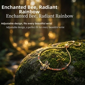 Detail of adjustable gold bee bracelet with rainbow crystals on mossy forest stone background