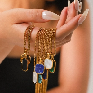 Octagonal natural stone pendant necklaces with gold box chains held by a model