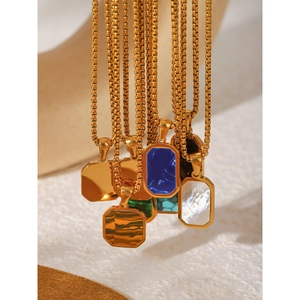 Close-up of gold box chain necklaces with colorful natural stone rectangular pendants