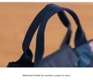 Detail of widened handles on a floral insulated lunch bag with high-density nylon webbing
